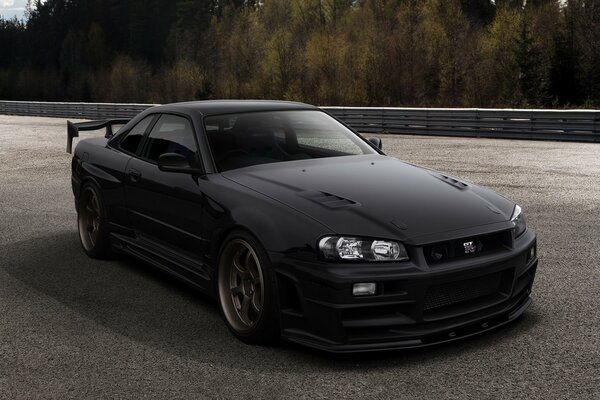 Black Nissan gtr34 on asphalt