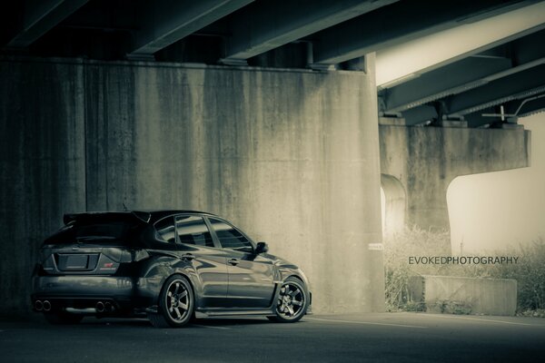 Coche negro Subaru bajo el puente