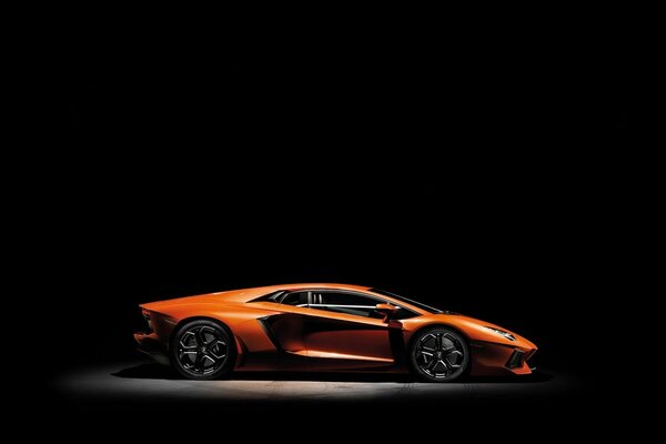 Lamborghini aventador naranja sobre fondo negro