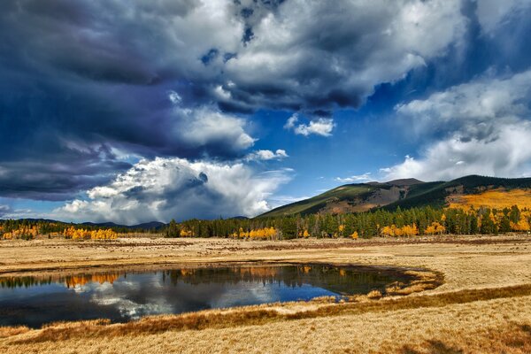 Lake with forest, mountains and clouds