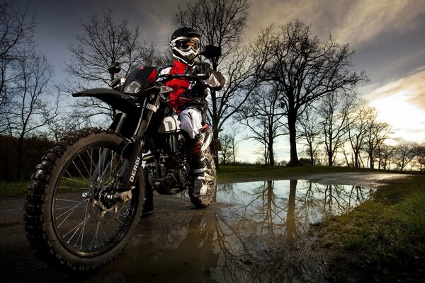 Motorcycle on the background of autumn nature near a puddle