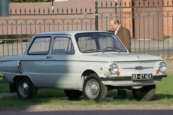 President Putin is standing next to a gray Zaporozhets and smiling