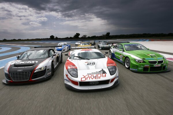 Supercars de course cool au début de la piste sur le fond de l horizon et le ciel gris, couvert de nuages