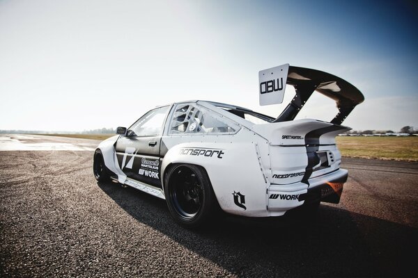 White and black Toyota Levin car on the road near the field