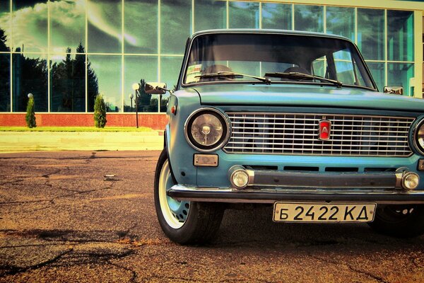 Image of a car of the Soviet automobile industry on the background of a mirrored building