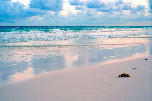 Waves of the sea on the background of the beach and clouds