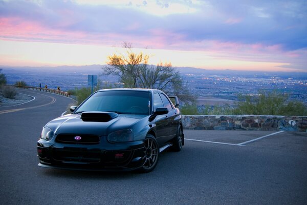 A black Subaru tuning car on the road in the morning