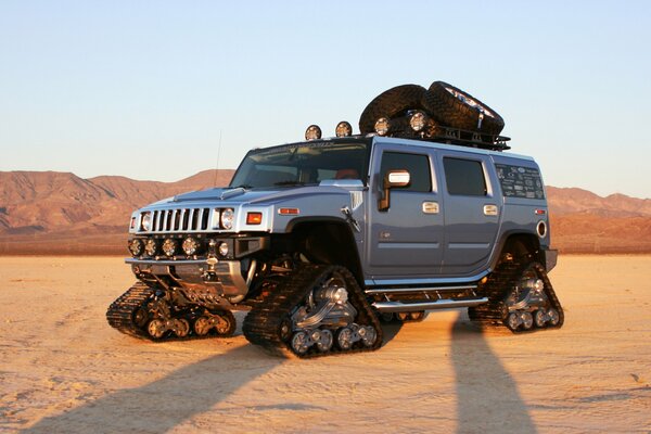 Powerful Hummer car in the desert on tracks instead of wheels