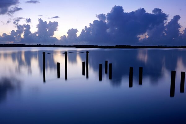 A beautiful sight on the pillars standing in the water and the reflection of clouds