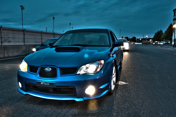 Blue Subaru car on the road in the evening