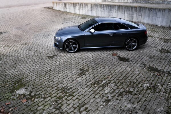 A black audi rs5 car stands on the plates