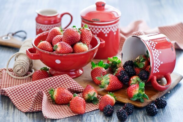 Stillleben mit roten Geräten und Erdbeeren