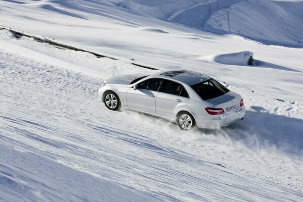 Mercedes pędzi po zaśnieżonej drodze