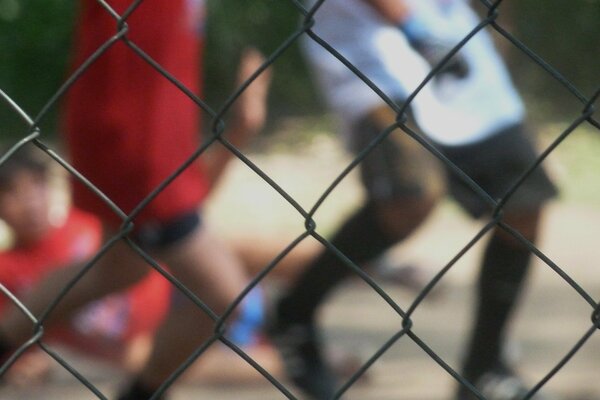 The boys kick the ball in the street