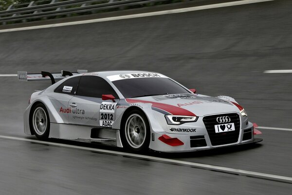 Серебристый Audi на гоночной трассе на скорости