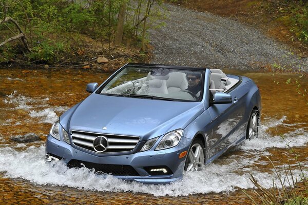 Ein glänzender Mercedes ohne Fahrer treibt einen flachen Fluss an