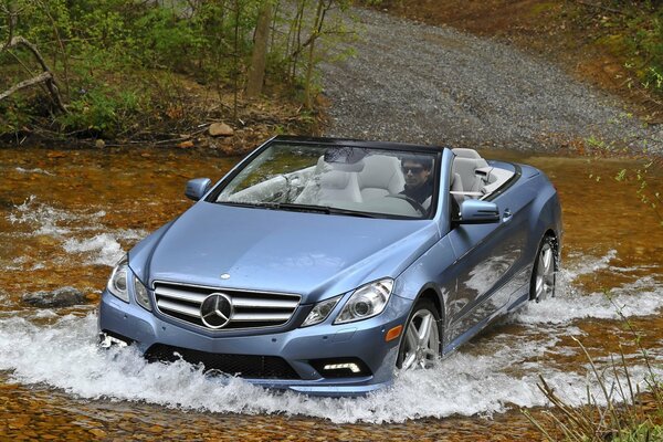 Mercedes brillante sans conducteur booste une rivière peu profonde