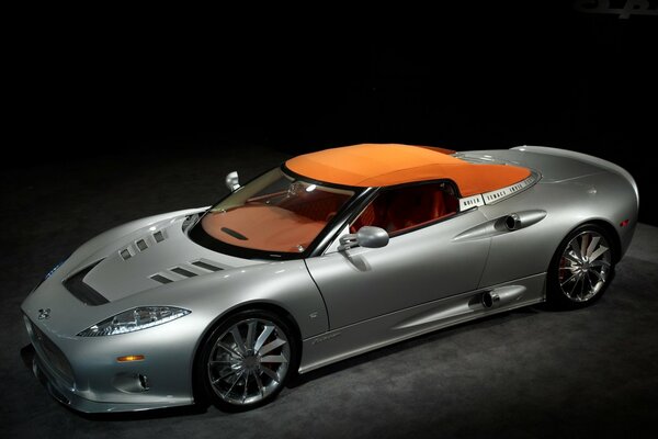 Voiture argentée avec dessus orange sur fond sombre