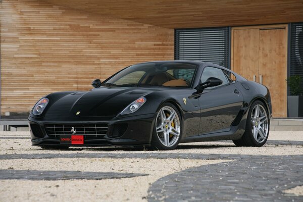 Schwarzer Ferrari in einem Holzgebäude