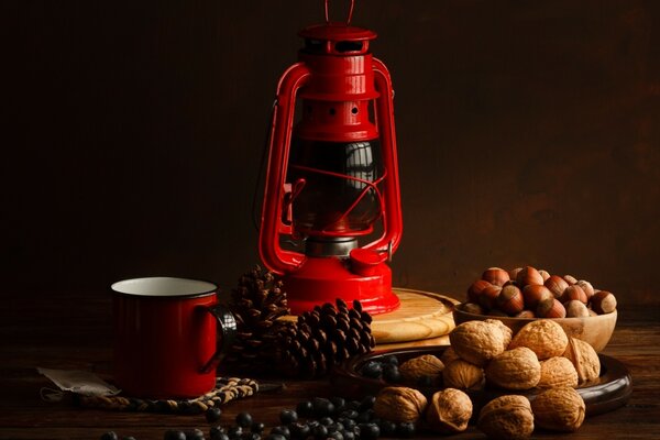 A picture with a mug, a lantern, cones and nuts