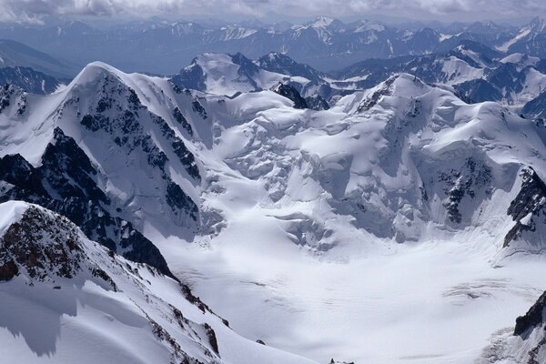 There is snow in the mountains and beautiful white clouds