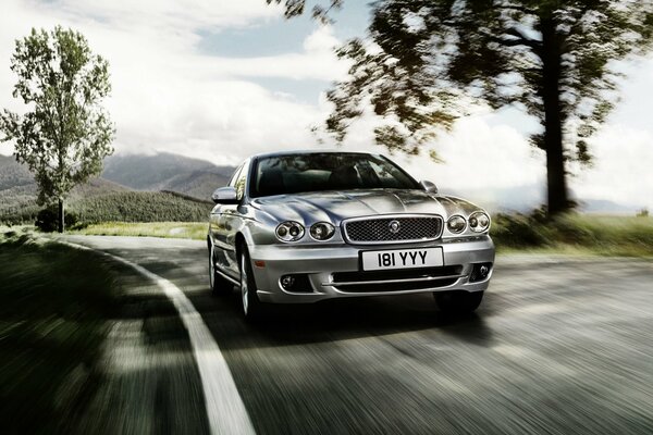 Imagen de un Jaguar x-type plateado en la carretera