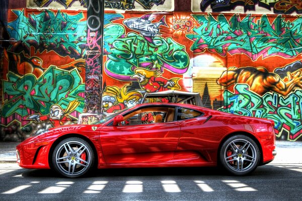 Coche rojo en la pared de fondo con graffiti