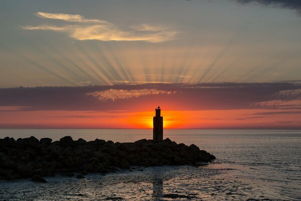 Paysage avec coucher de soleil et phare