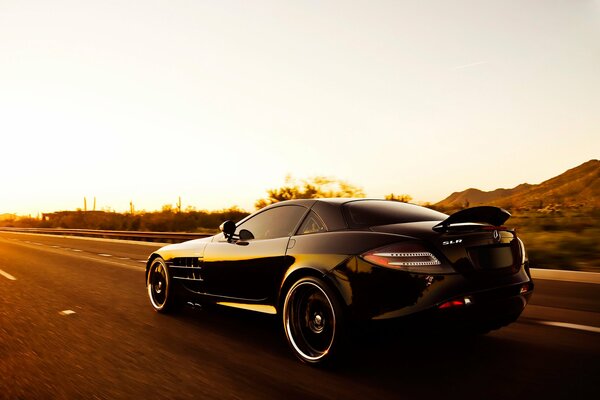 Mercedes benz noire Monte au coucher du soleil