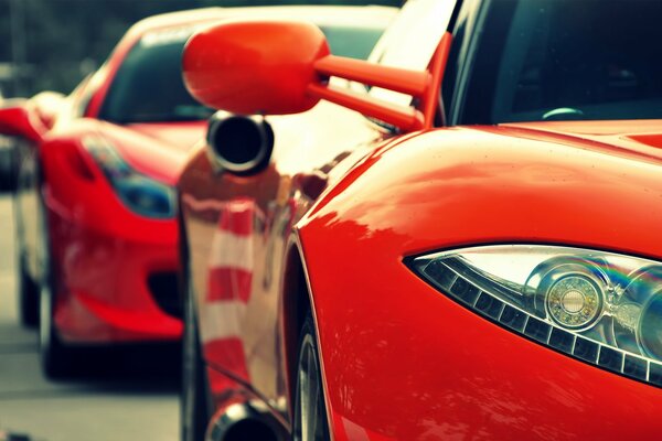 Two red cars with cool headlights