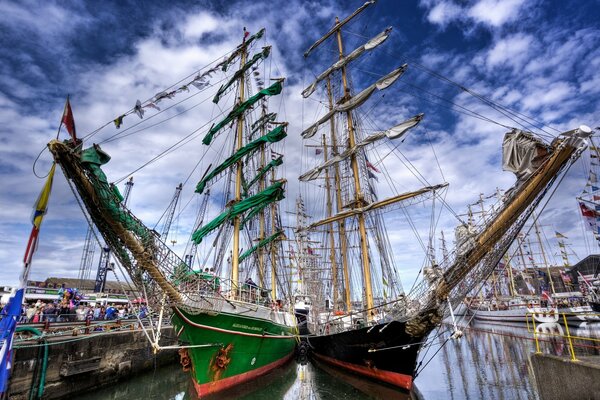 Yachts avec des voiles vertes et blanches au quai