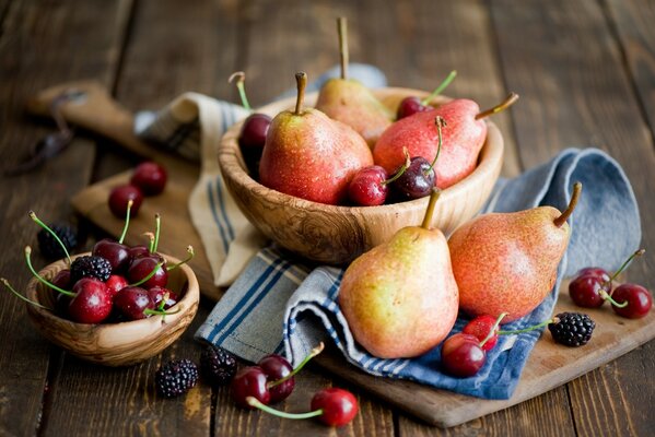 Früchte und Beeren liegen köstlich in Holzschüsseln