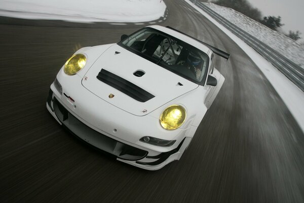 Un Porsche blanco corre por una pista vacía