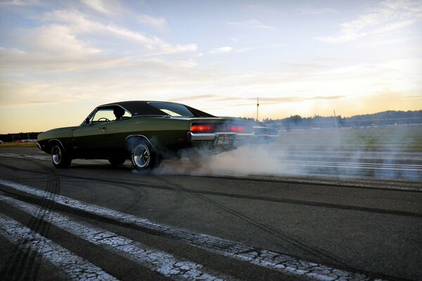 A green car is driving on the road