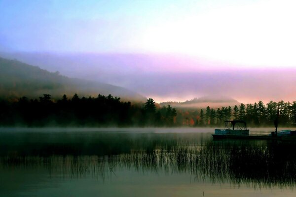 Il y a du brouillard. Aube. Rivière. Bateau