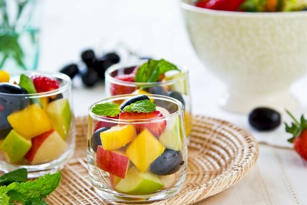 There are bowls with fruit salad on a tray