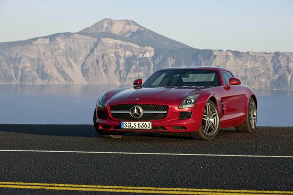 Red Mercedes on the background of a mountain lake