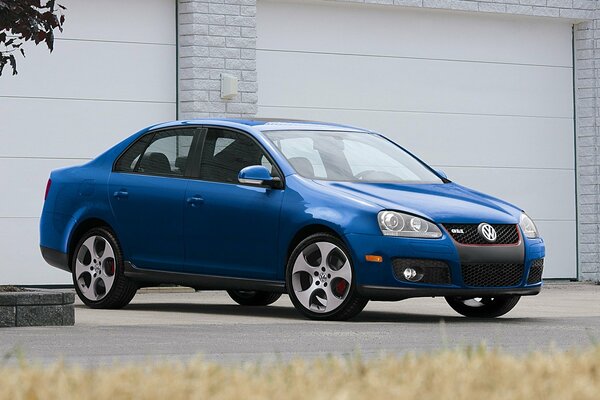 Blue car with red calipers on the background of garages