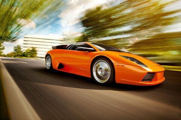 Una Lamborghini arancione brillante corre lungo la strada