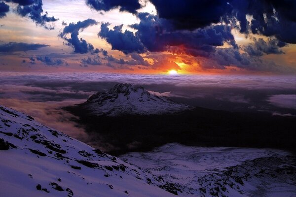 Hermosa puesta de sol en las montañas nubladas