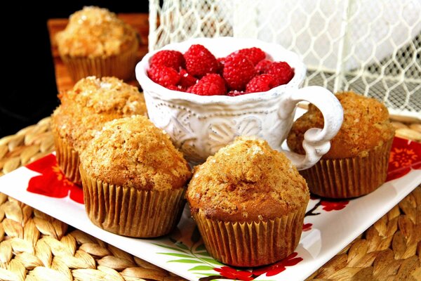 Muffins en un plato cuadrado con frambuesas en una taza