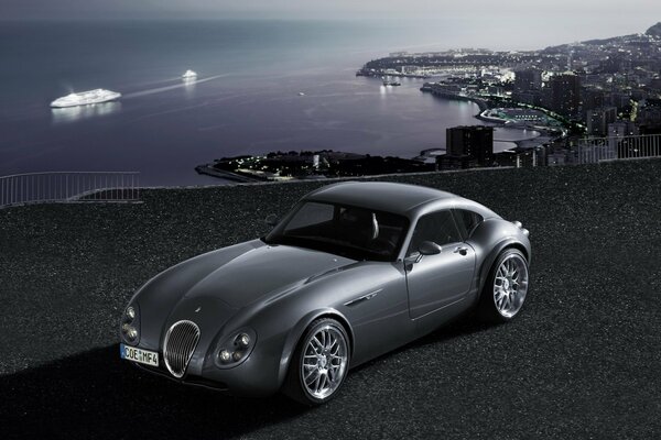 Night photo of a car and a cruise ship in the background