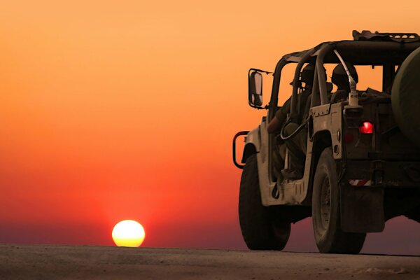 Militärfahrzeug auf Sonnenuntergang Hintergrund