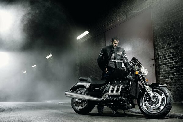 Motorcyclist with a motorcycle at night on the road