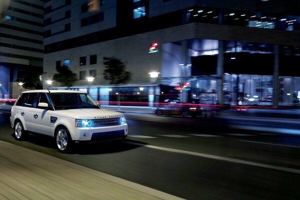 SUV blanc sur fond de ville de nuit