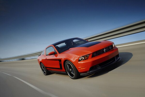 Racing red mustang makes a turn on the track