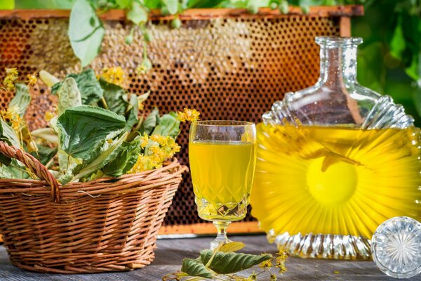 Un panier de tilleul se tient à côté d une boisson jaune