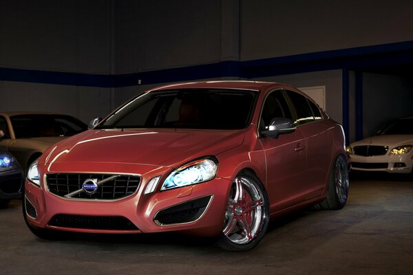 Red Volvo with headlights on