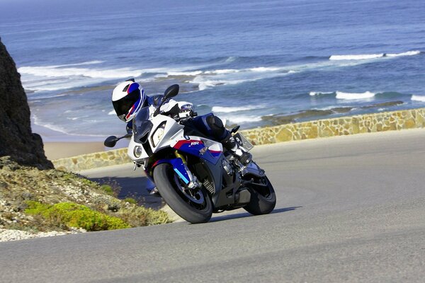 Le voyage d un motard sur une route de montagne près de la mer