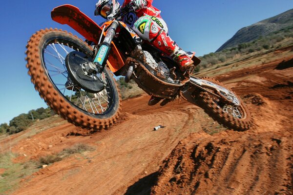 La moto roule sur la boue et le sable